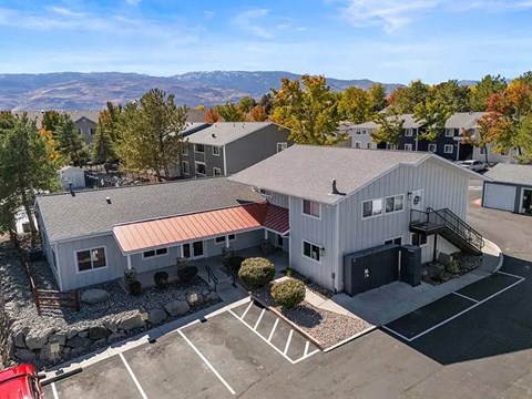 A parking lot with a building and a mountain in the background.
