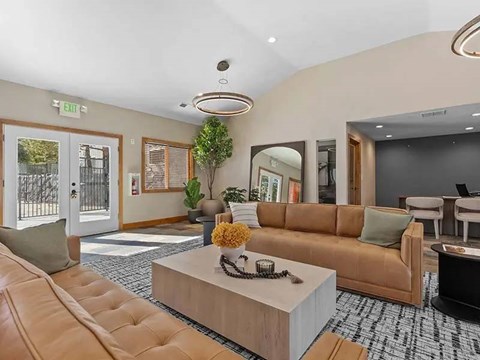 A well-lit living room with a brown sofa and a coffee table.