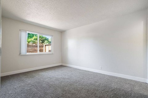 A room with a window and a view of a backyard.
