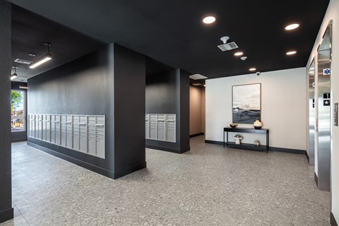 A modern office space with a long black wall and a framed picture on the wall.