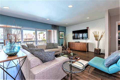 A living room with a grey couch and a blue chair.
