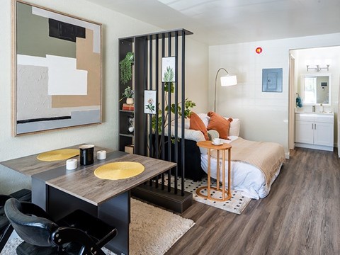 A modern bedroom with a bed, chair, and a painting on the wall.