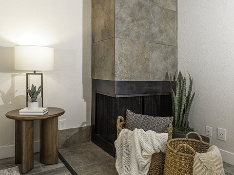 A living room with a fireplace and a plant.