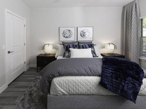 A bedroom with a bed, two lamps, and two wall art pieces.