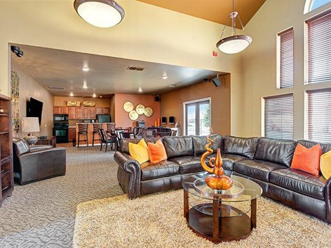 A living room with a black leather couch and a coffee table.