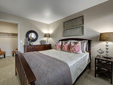 A bedroom with a large bed and a mirror on the wall.