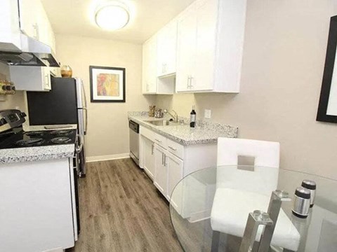 A kitchen with white cabinets and a black stove top.