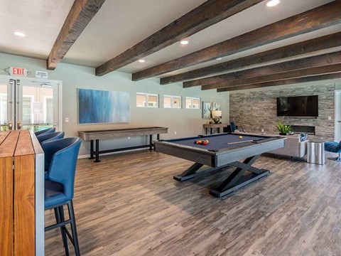 A room with a pool table and a fireplace.