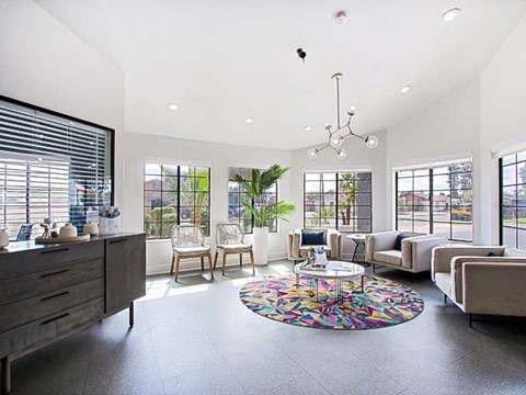 A modern living room with a large rug and a chandelier.