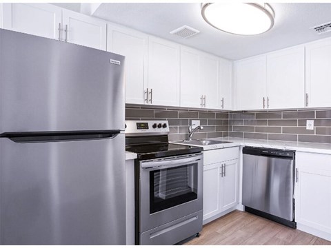 A modern kitchen with a stainless steel refrigerator and oven.