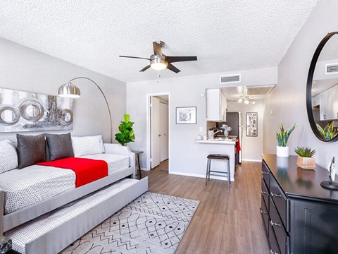 A modern bedroom with a large bed and a kitchen area.