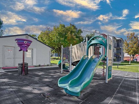 A playground with a green slide and a purple object.