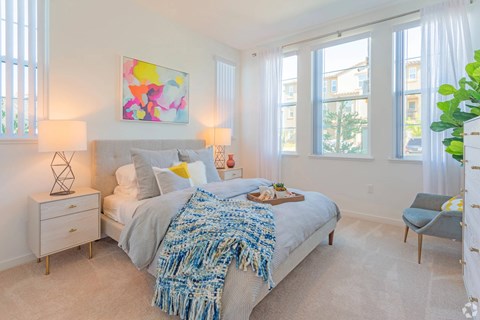 A bedroom with a large bed and a painting on the wall.
