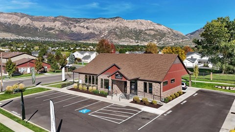 A parking lot in front of a building with a mountain in the background.