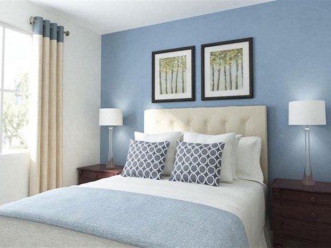 A bed with a white headboard and two pillows in a room.