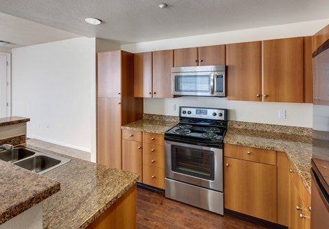 A kitchen with brown cabinets and a granite countertop.