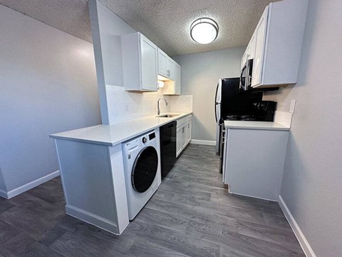 A small kitchen with a washing machine and a refrigerator.