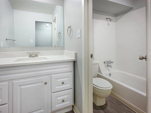 A white bathroom with a toilet, sink, and bathtub.
