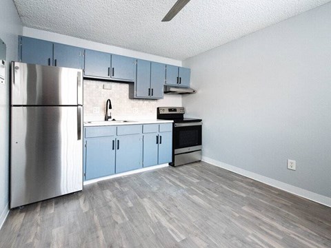 A kitchen with a stainless steel refrigerator and blue cabinets.