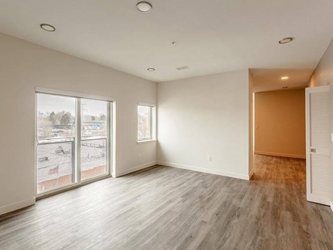 A room with a sliding glass door and a wooden floor.