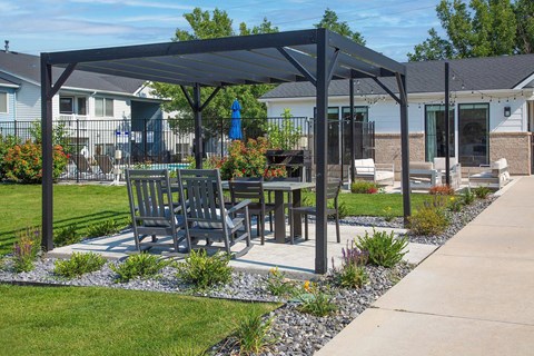 A patio with a table and chairs under a black canopy.