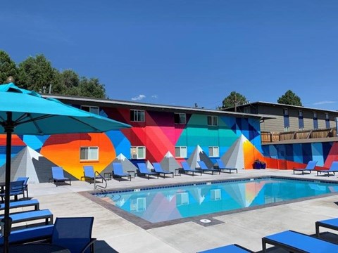 A colorful mural on a building behind a pool.