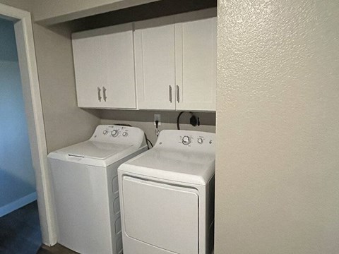 A white washing machine and dryer in a small laundry room.