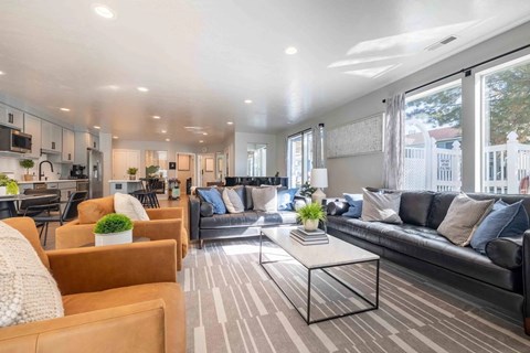 A modern living room with a black couch and a coffee table.
