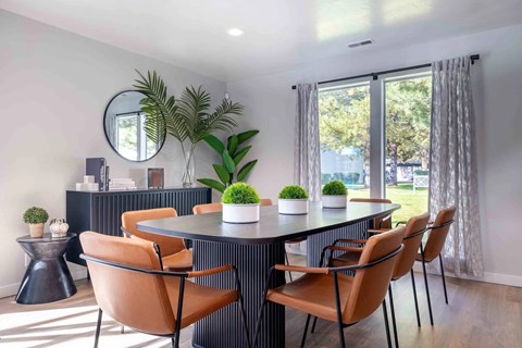 A modern dining room with a round table and chairs.