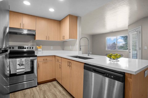 A modern kitchen with wooden cabinets and stainless steel appliances.