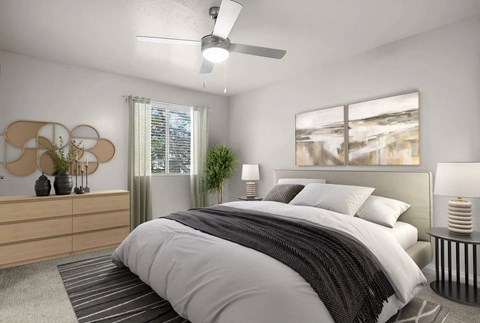 A bedroom with a large bed and a ceiling fan.