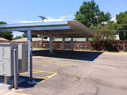 A parking lot with a covered area and a yellow line painted on the ground.