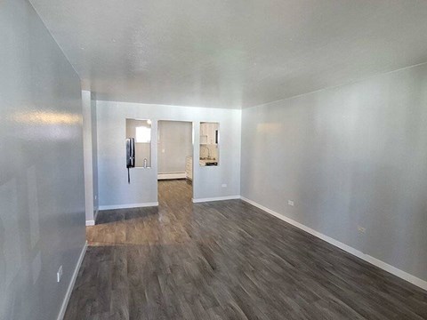 A room with wooden flooring and white walls.