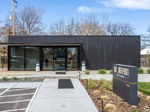 The Outpost is a modern building with a black exterior and glass doors.