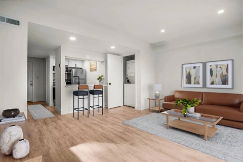 A living room with a brown couch, a coffee table, and a bar area.