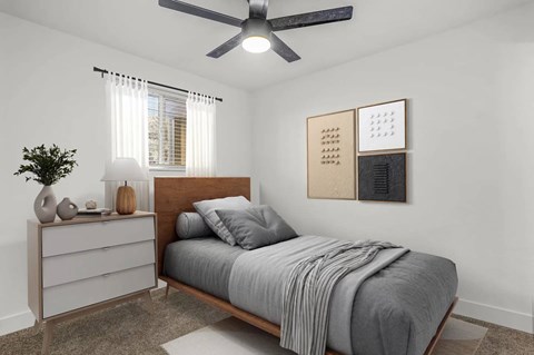 A bedroom with a bed, a dresser, and a ceiling fan.