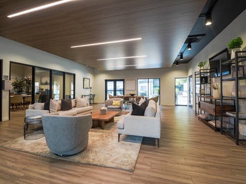A modern living room with a large grey armchair and a wooden floor.