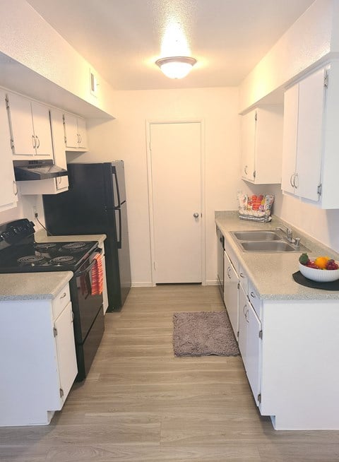 a renovated kitchen with white cabinets and a black stove and refrigerator