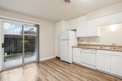 A kitchen with white cabinets and a white refrigerator.