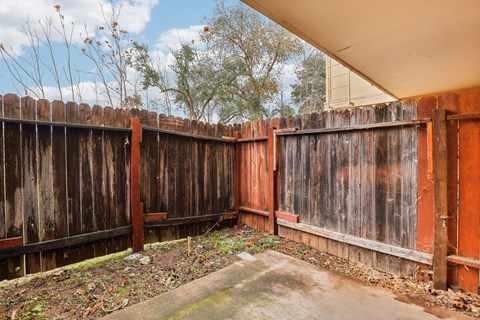 A brown wooden fence with a concrete slab in the middle.