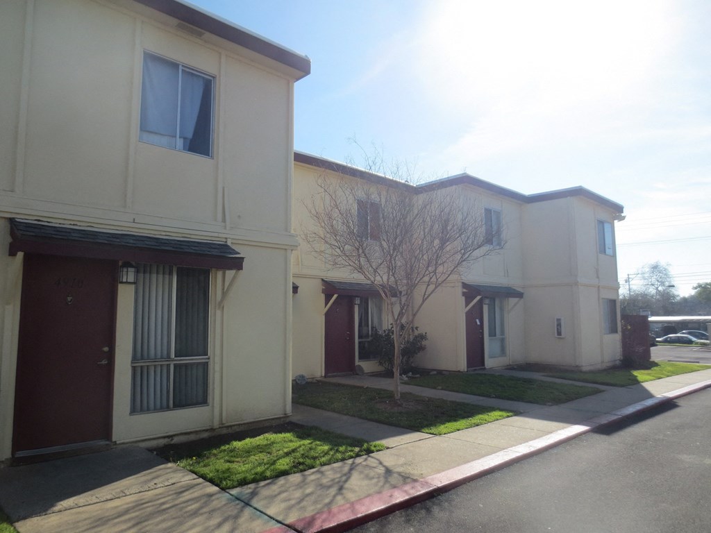 a group of houses on a street with a sidewalk