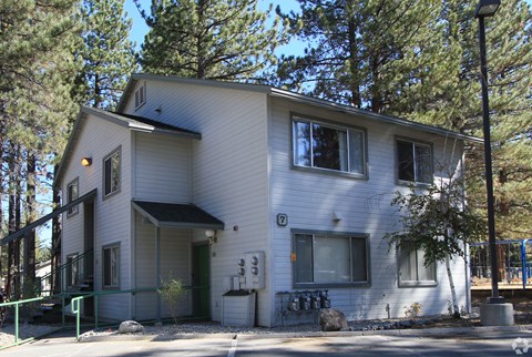 A two-story house with a white exterior and a green door.
