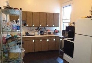 A kitchen with wooden cabinets and a white refrigerator.