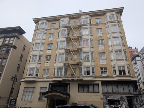 A large tan building with a balcony on the second floor.