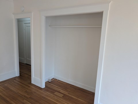 A room with a white wall and a wooden floor.