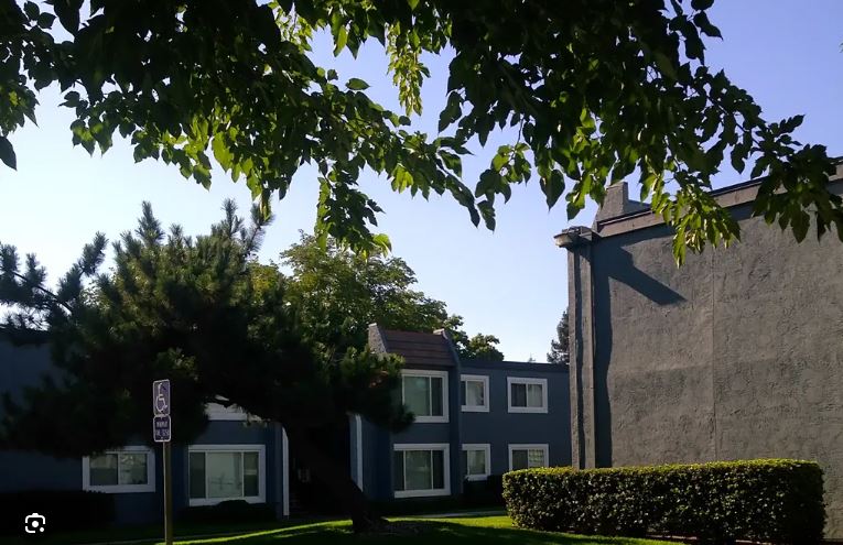 A building with a sign on a pole in front of it.