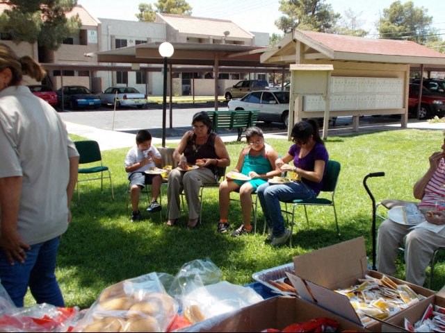 a group of people sitting in lawn chairs eating food