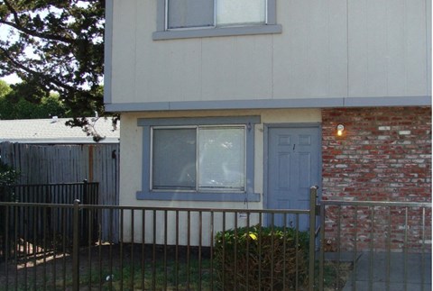 a house with a blue door and a red brick wall