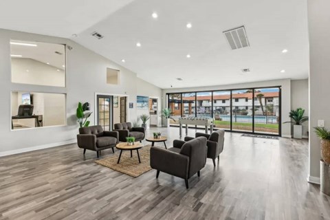 A spacious living room with dark brown sofas and a large window overlooking a pool.