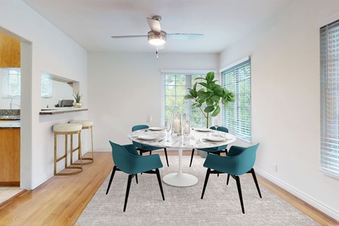 A dining room with a white table and blue chairs.